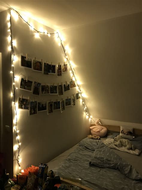 A Bedroom With Lights Strung From The Ceiling And Pictures Hanging On