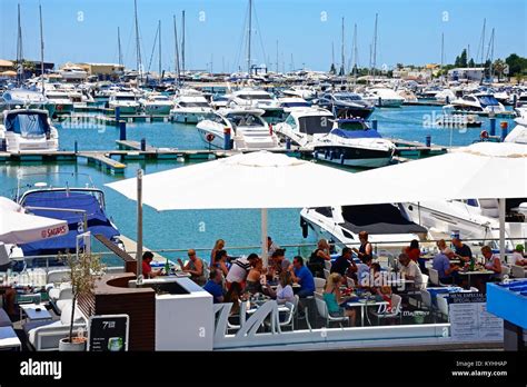 Luxury Boats Moored In The Marina With Waterfront Restaurants In The