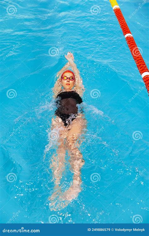 One Female Swimmer In Swimming Cap And Goggles Training At Pool