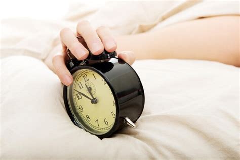 Premium Photo Cropped Hand Holding Alarm Clock On Bed