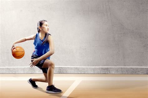 Fille Asiatique Attirante Dans Luniforme Bleu De Sport Sur Des Mouvements De Pivot De Basket