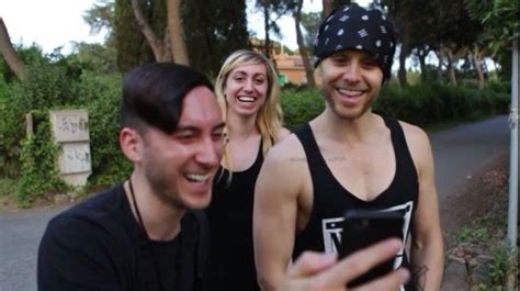 Two Men And A Woman Taking A Selfie With Their Cell Phone In Front Of Them