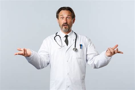 Premium Photo Worried Indecisive Male Doctor In White Coat Pointing