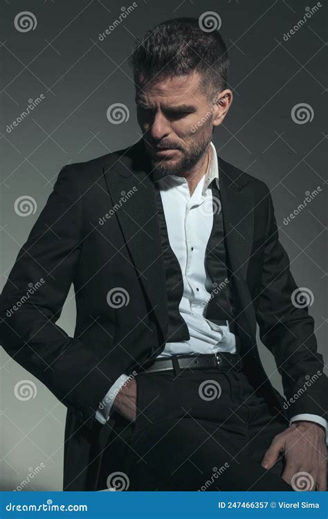 Seated Bearded Businessman In Black Suit Holding Hand In Pocket Stock