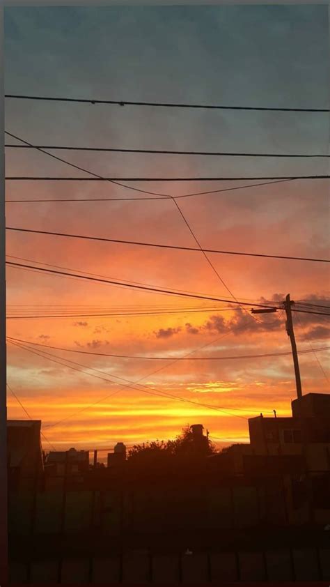 The Sun Is Setting Behind Power Lines And Telephone Poles In Front Of