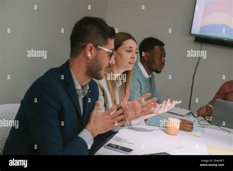 Blonde Business Woman Explaining Something While Sitting With Her Colleagues At The Office Desk
