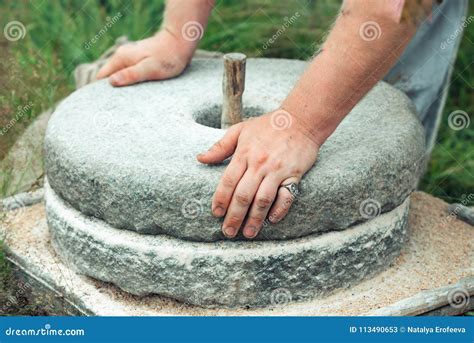 The Ancient Stone Hand Grain Mill Men`s Hands Rotate A Stone Millstone