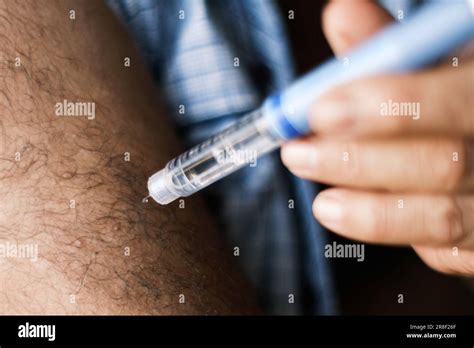 Close Up Image Of A Brunette Man Self Administering An Insulin