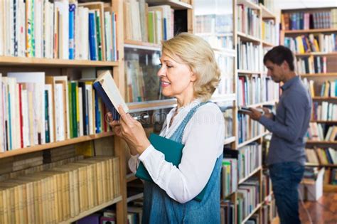 Positive Mature Woman Looking At Open Book Stock Photo Image Of