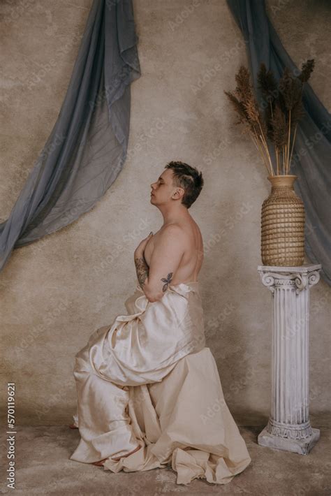 Profile Of A Shirtless Non Binary Person Sitting On Pedestal With Hands