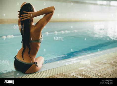 Viewe An Junge Frau Im Bikini Am Pool Sitzen Stockfotografie Alamy