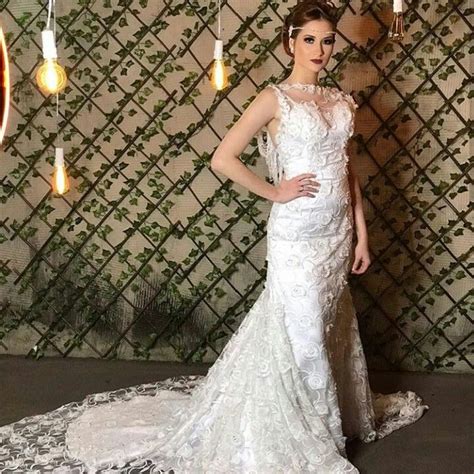 A Woman Standing In Front Of A Mirror Wearing A Wedding Dress