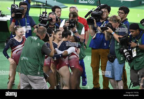 American Gymnasts Hug In Jubilation Surrounded By Photographers As