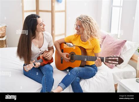 Two Women Mother And Daughter Playing Classical Guitar And Ukulele At