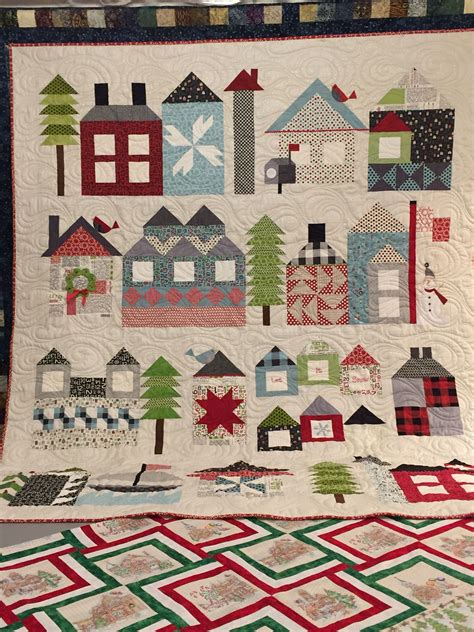 A Quilt With Houses And Trees On It