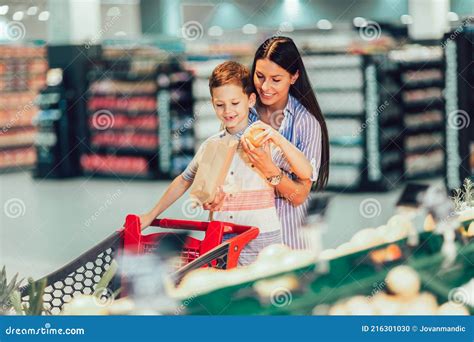 Madre E Hijo Comprando Fruta En Tienda De Comestibles O Supermercado