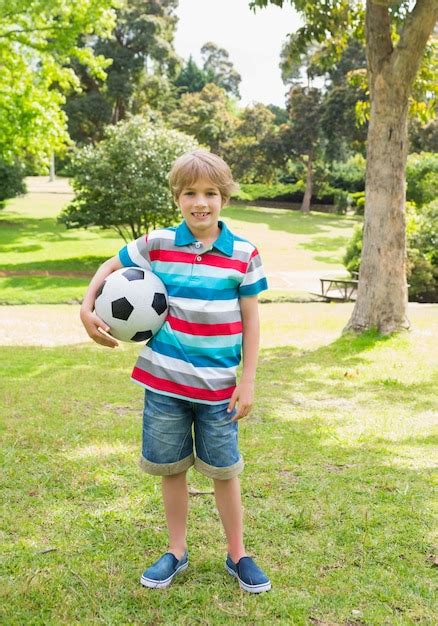 Retrato de cuerpo entero de un niño con pelota en el parque Foto Premium