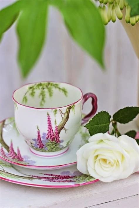 A Cup And Saucer On A Table With Flowers