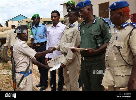 A Somali Police Officer Receives A Certificate After Completing Close