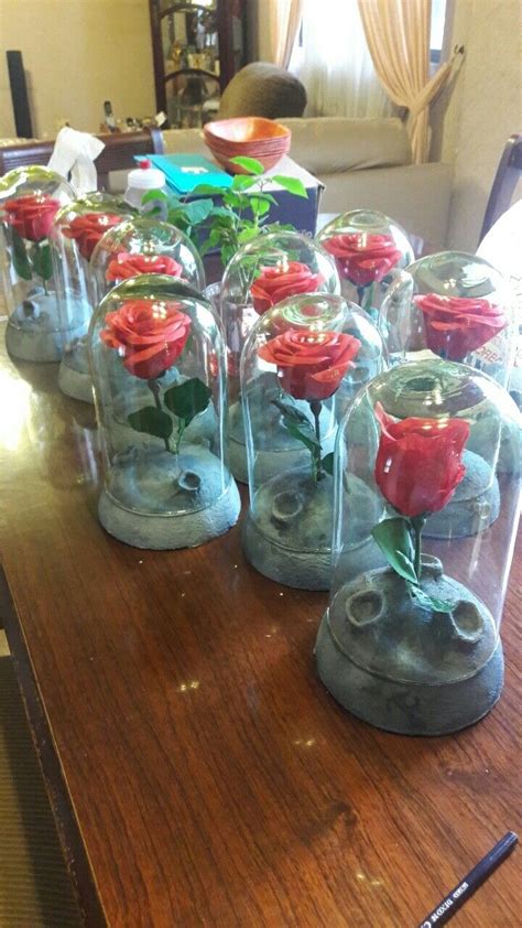 There Are Many Glass Vases With Red Roses In Them On The Wooden Table Top