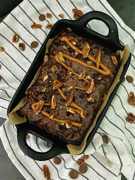 A Chocolate Cake With Pecans And Caramels On Top In A Baking Pan