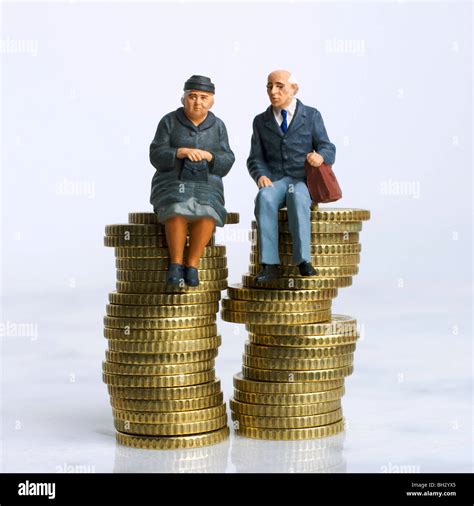 Old People Couple Figurines Sitting On A Pile Of Money Coins