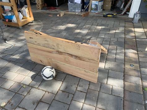 a soccer ball is sitting on the ground next to a wooden box that has ...