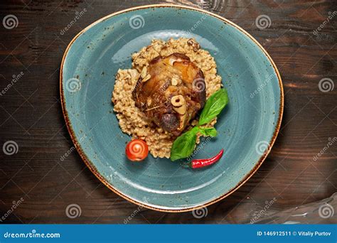 Plato De La Carne Del Nudillo Con Un Acompa Amiento En Una Placa Azul