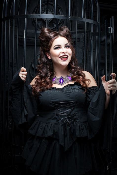 De Mooie Mollige Vrouw Bevindt Zich Door De Zwarte Kooi Stock Afbeelding Image Of Brunette