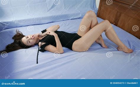 Modelo Que Se Posiciona Na Cama De Lingerie Negra Imagem De Stock