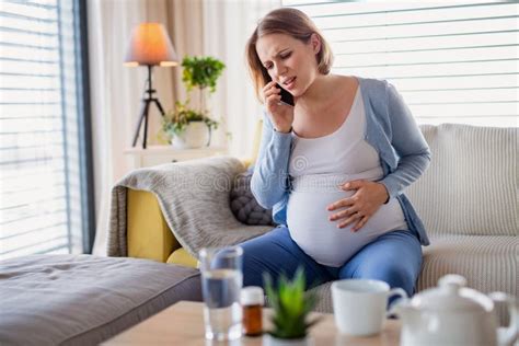 Portrait Of Pregnant Woman In Pain Indoors At Home Making Emergency