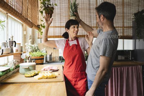 Happy Mature Couple Cooking Together At Home Having Fun Preparing