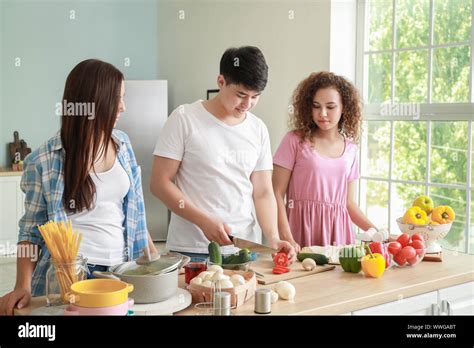 Happy Friends Cooking Together In Kitchen Stock Photo Alamy