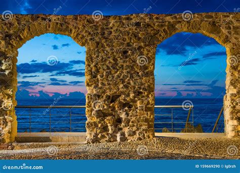 Sunset View Of Tyrrhenian Sea Through Stone Arch Gate In Cefalu Sicily