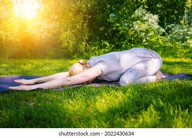 Mindful Mature Woman Meditating By Water Stock Photo
