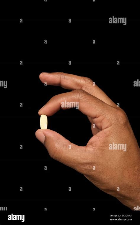 Hand Holding Pill Between Finger Hi Res Stock Photography And Images