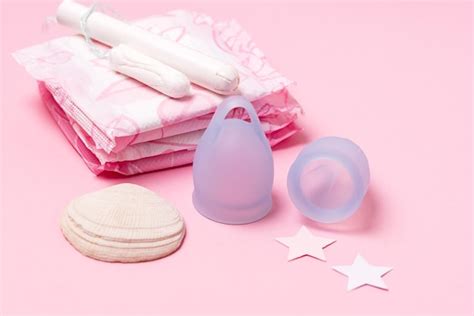 Pada copa menstrual tampón sobre fondo rosa concepto de días críticos