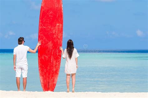 Young Couple With Red Surfboard During Tropical Vacation Stock Image