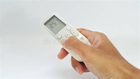 Hand Holding Air Conditioner Remote Control To Adjust The Temperature