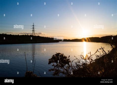 Pylon Power Lines Against Sunsetting Sky Crossing The River Tyne At