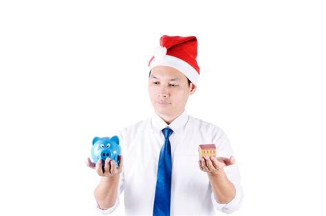 Premium Photo Man Holding Piggy Bank And Mode House Against White