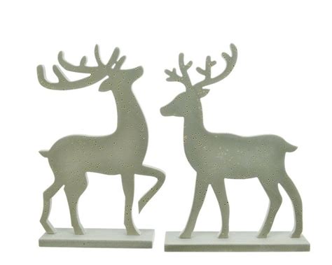 Two Metal Deer Figurines Sitting Next To Each Other On Top Of A White