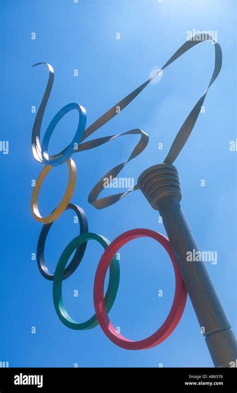 A Sculpture Of The Olympic Torch With The Olympic Rings Symbol In