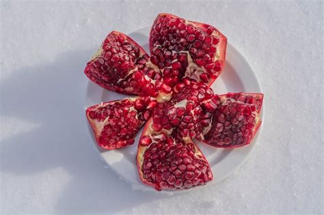 Fruta De Granada Abierta Con Semillas Rojas Sobre Una Nieve Blanca En