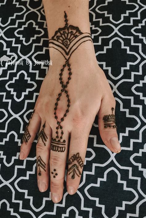 A Woman S Hand With Henna Tattoos On It