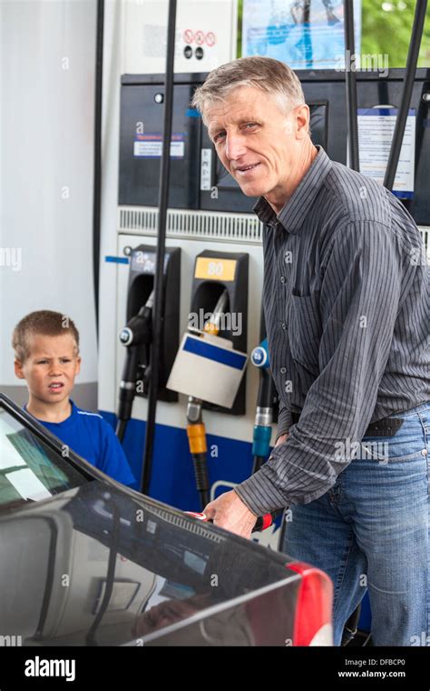 Mature Man With Son Refueling Vehicle With Gasoline Stock Photo Alamy