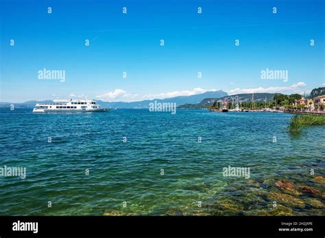 Ferry Boat Is Arriving In The Small Port Of The Village Of Bardolino