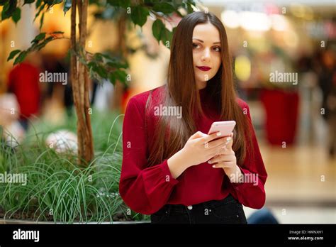 Brunette Woman Sitting On The Street And Texting On The Phone Stock