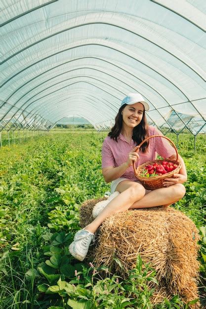 Mujer Recogiendo Fresas En La Granja Foto Premium