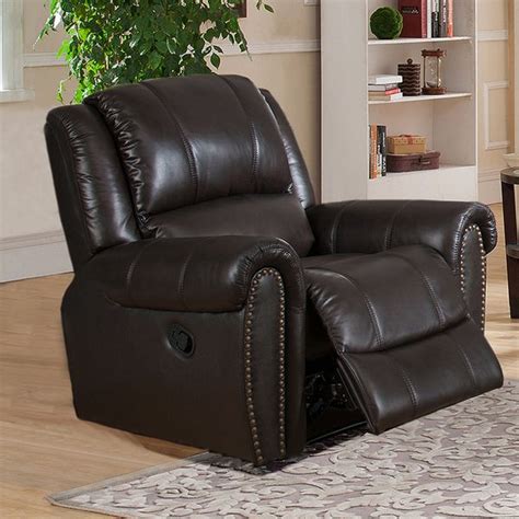 A Brown Recliner Chair Sitting On Top Of A Rug In Front Of A Book Shelf